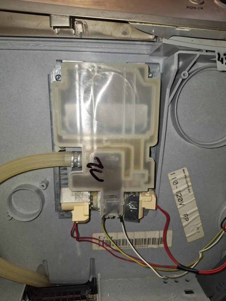 Fisher & Paykel DishDrawer top drawer dispenser assembly area exposed during OEM service part replacement in a Roxboro kitchen, Calgary