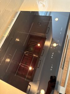 Detail of the new Bosch glass-ceramic top showing clean cooking-zone marks and intact control panel after replacement