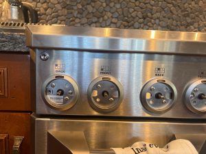 GE Monogram pro range with control knobs removed exposing the model badge ZDP486NDP4SS during griddle section diagnostic in Priddis, AB