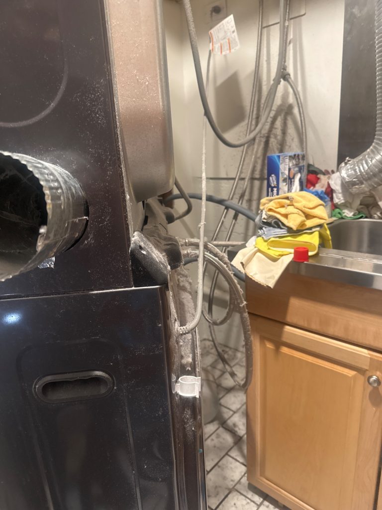 Disconnected dryer exhaust duct on an LG stacked laundry center before reconnection in Burnaby, BC