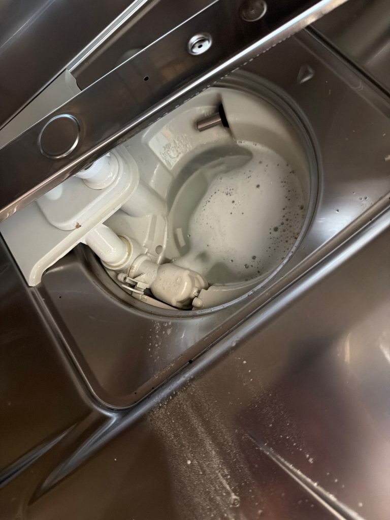 Sump area of a Miele built-in dishwasher during water-handling diagnosis in Coral Springs, Calgary