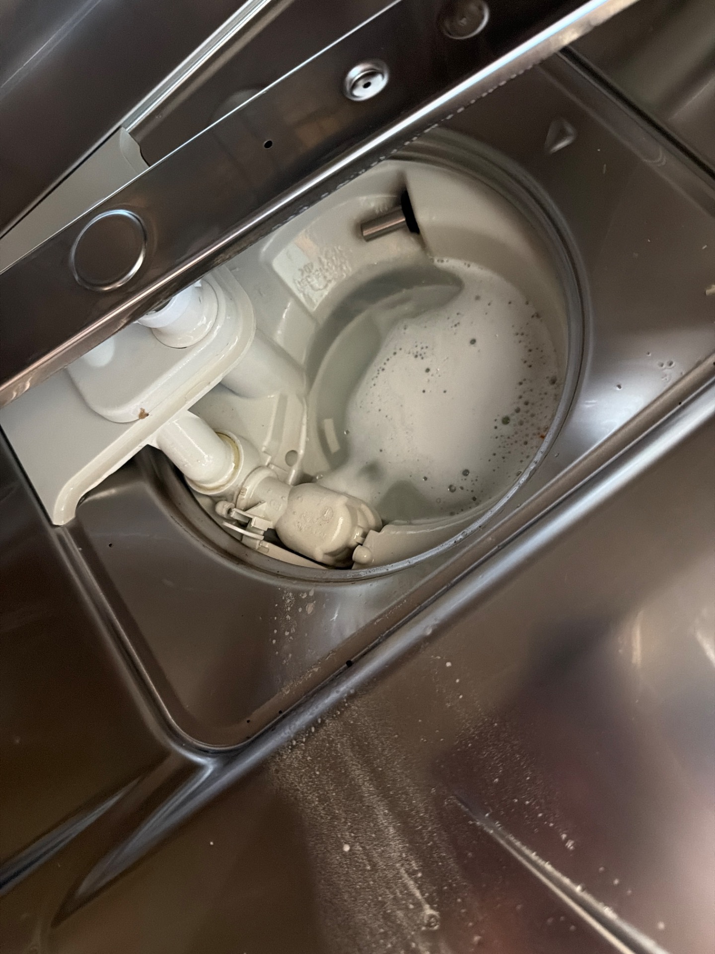 Sump area of a Miele built-in dishwasher during water-handling diagnosis in Coral Springs, Calgary