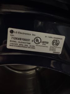 TechVill technician opening rear panel access on an LG DLEX8377 electric dryer in Cranston, SE Calgary, to inspect the heating element