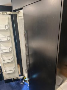 Panel-ready Thermador built-in freezer column reinstalled flush with dark cabinetry after repair in Bayview, Calgary
