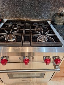 Wolf GR304 30-inch gas range with four burners and red control knobs during a simmer ignition diagnosis in Altadore, Calgary