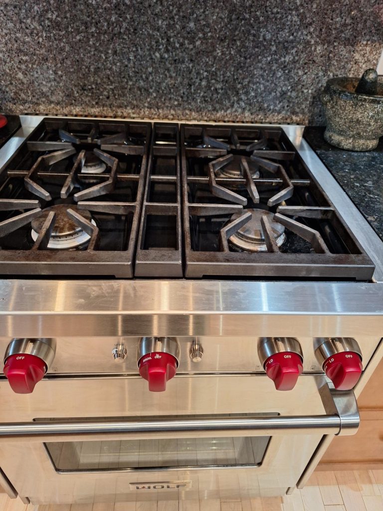 Wolf GR304 30-inch gas range with four burners and red control knobs during a simmer ignition diagnosis in Altadore, Calgary
