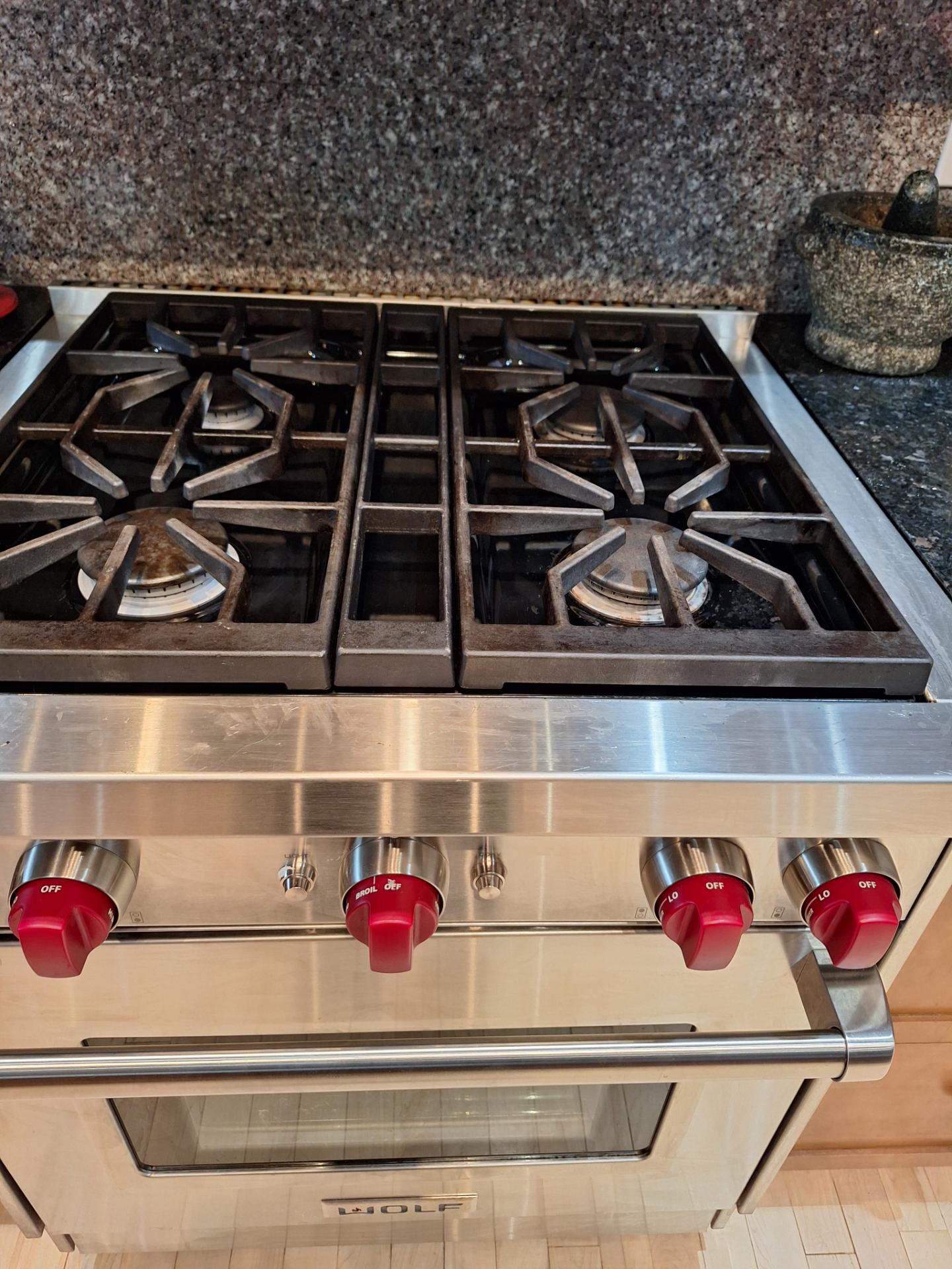 Wolf GR304 30-inch gas range with four burners and red control knobs during a simmer ignition diagnosis in Altadore, Calgary