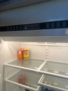 Sealed-system recharge in progress on the Viking built-in refrigerator after Schrader valve correction