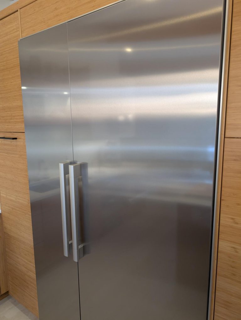 TechVill technician replacing the OEM Miele water filter on a KIMSDF18US built-in refrigerator during a scheduled inspection in Brookside, Edmonton