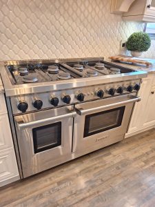 TechVill technician duplicating the continuous-clicking symptom on the right-front burner of a Wolf GR488 48-inch pro-style gas range in Priddis, Alberta