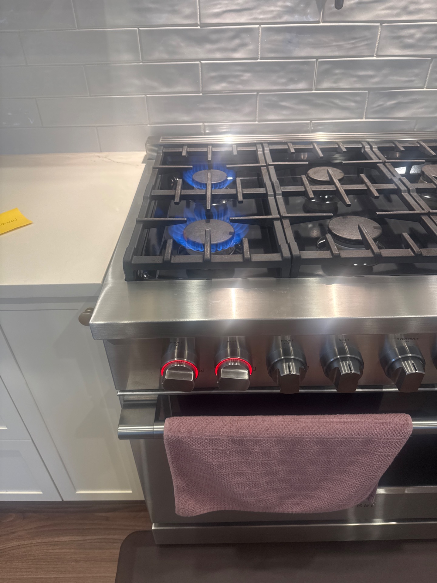 Fisher & Paykel gas range front-left burner lit with a clean blue flame after cleaning in Burnaby