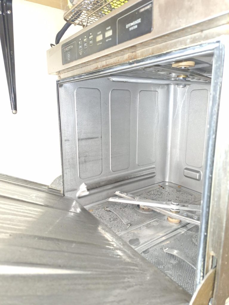 TechVill technician diagnosing the control panel of a Fagor commercial dishwasher in downtown Calgary
