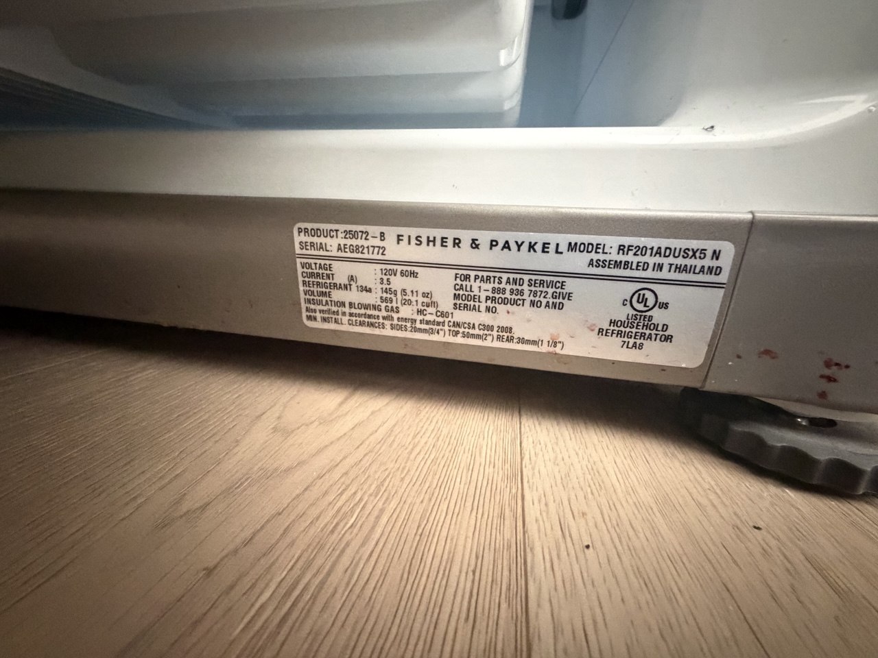 Fisher & Paykel rating plate at the base of the refrigerator cabinet confirming model RF201ADUSX5n, used to identify the correct OEM ice maker assembly