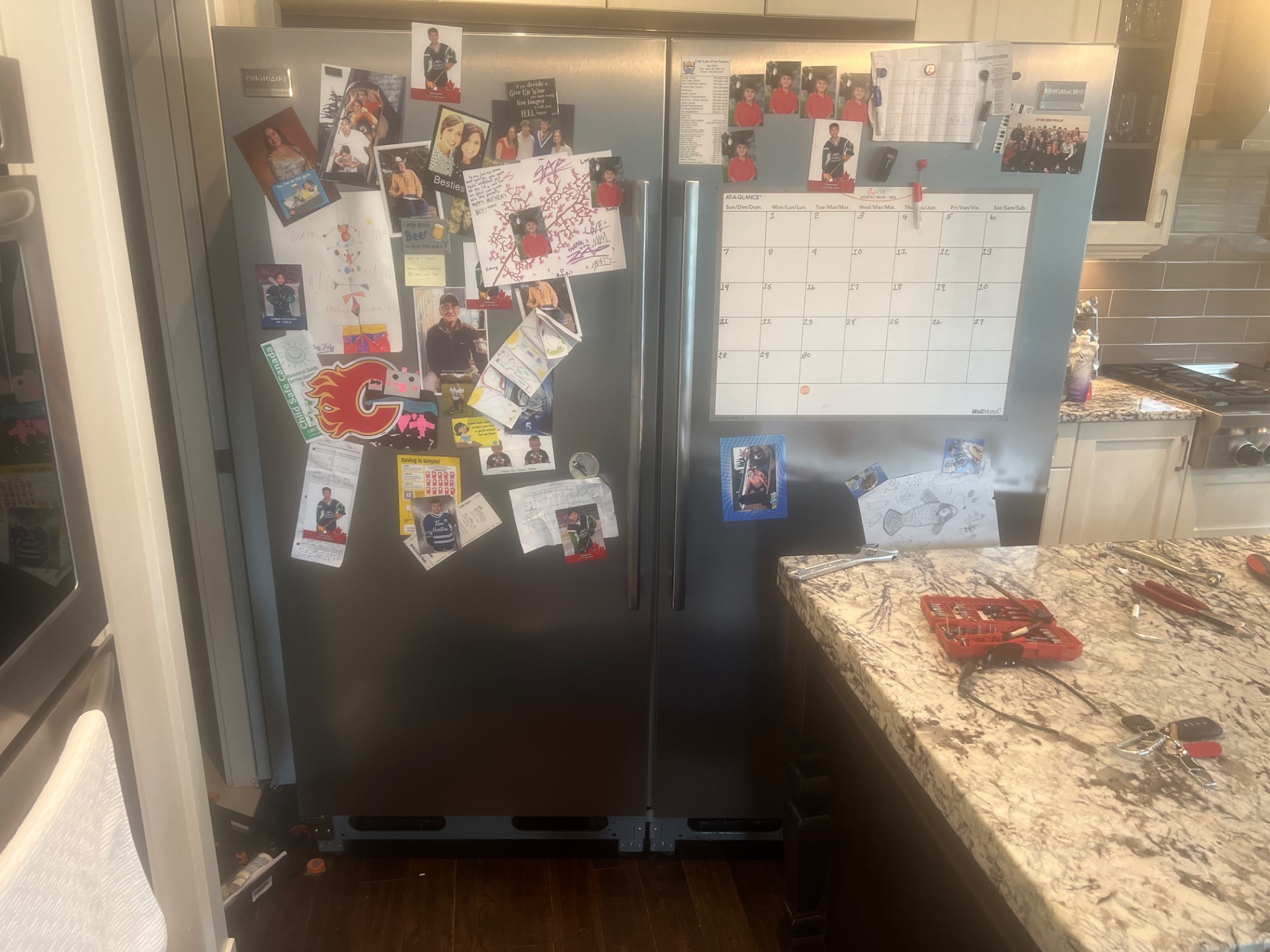 Frigidaire refrigerator in an Aspen Woods, Calgary kitchen with TechVill diagnostic tools laid out on the counter during a sealed-system repair