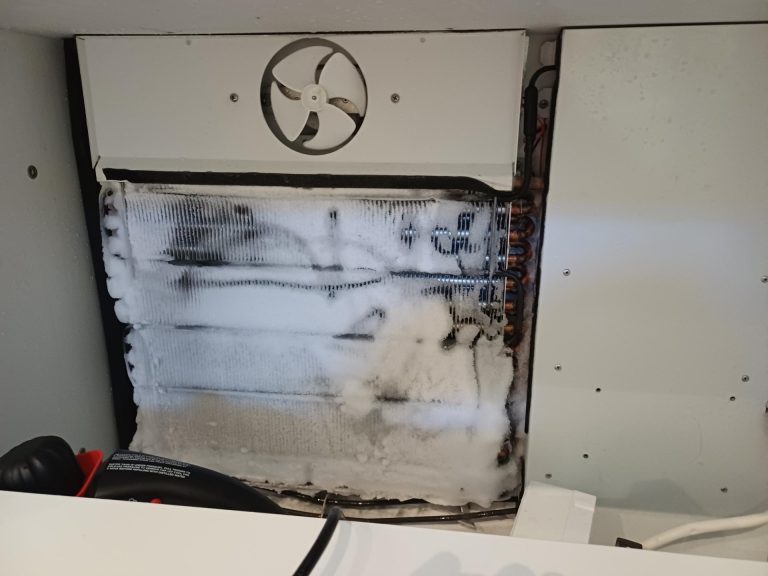 Frost-covered evaporator coil and fan inside a Sub-Zero 736TCI built-in refrigerator during a defrost system diagnosis in inner SW Calgary