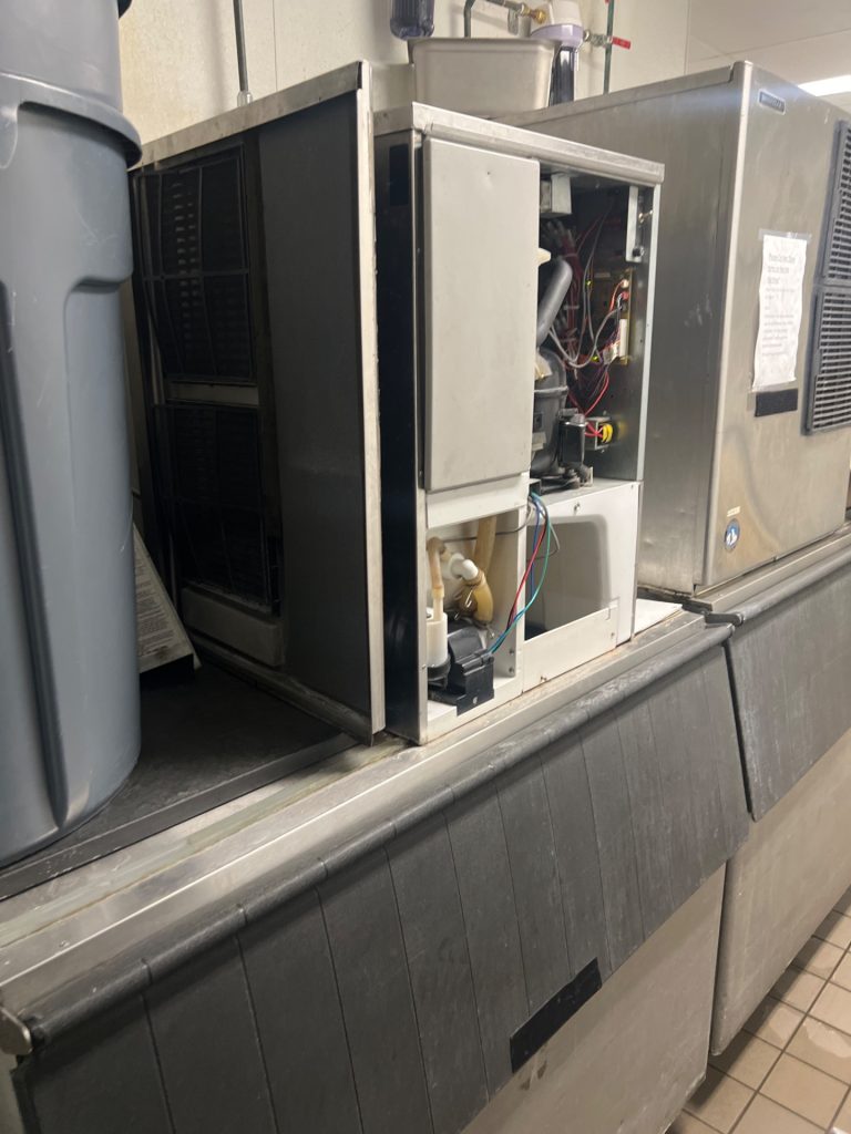 TechVill technician cleaning the condenser coil on a Hoshizaki commercial ice maker in Calgary