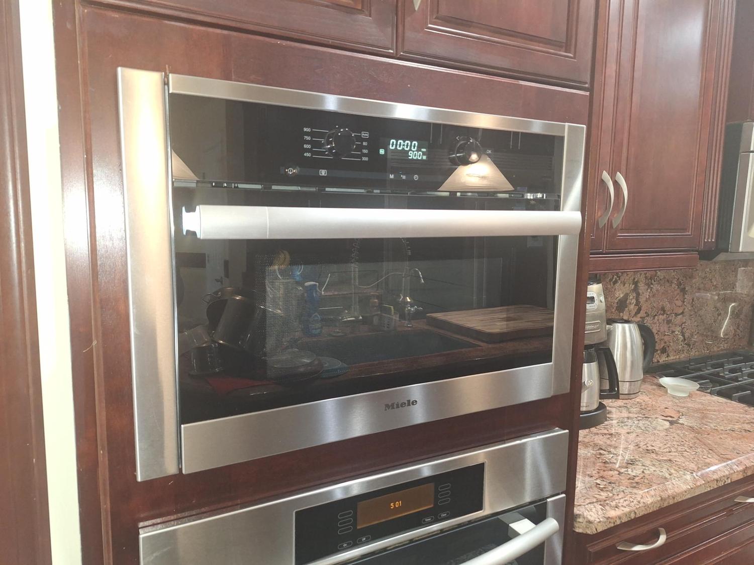 Built-in Miele M6160 microwave installed in a wall cabinet in a Pump Hill, Calgary kitchen