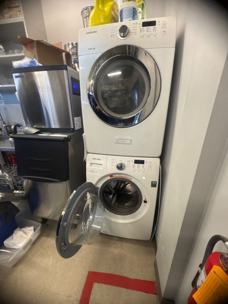 Samsung front-load washer with the door open during diagnosis at a property near the Calgary airport