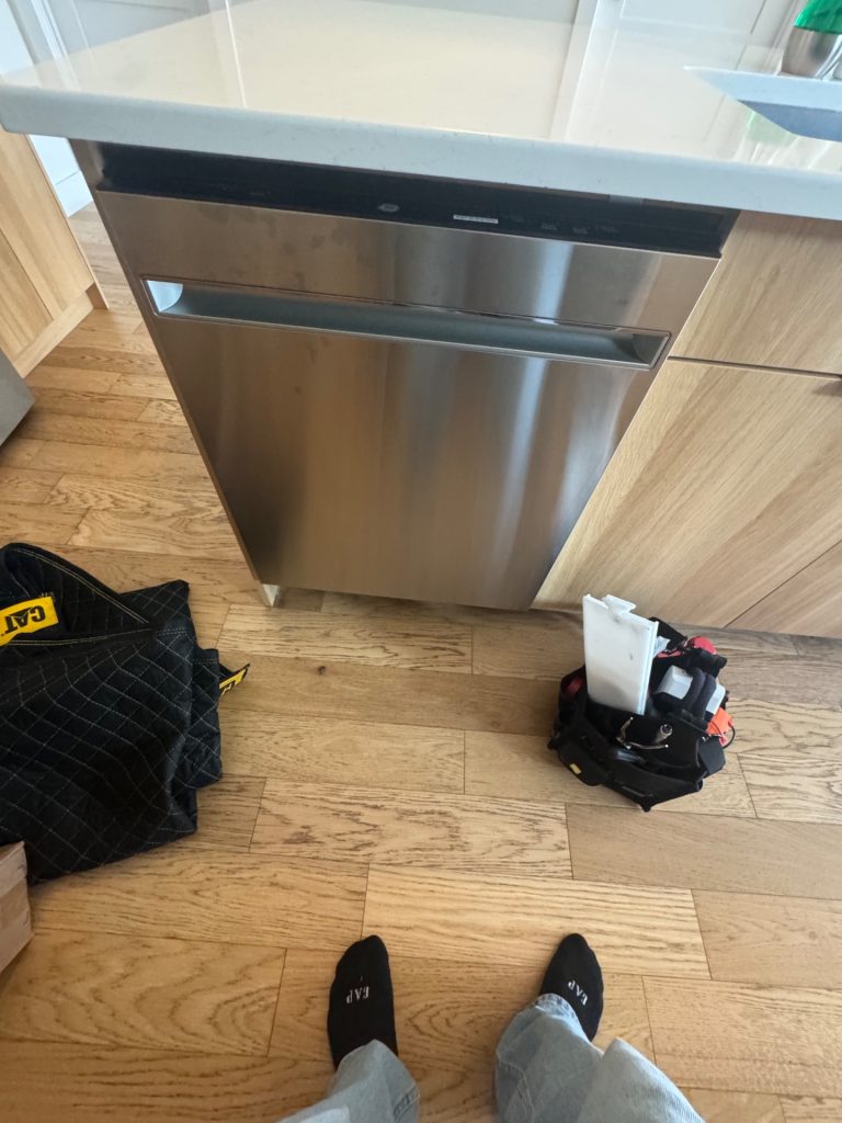 GE built-in dishwasher installed under a quartz island counter in a Central Canmore kitchen before wash pump replacement