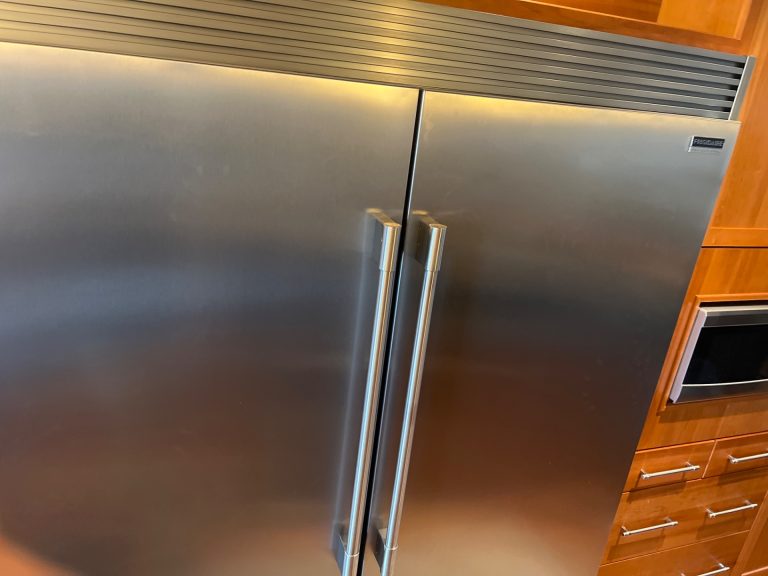 Stainless steel Frigidaire Professional built-in refrigerator integrated into wood cabinetry in a Central Canmore home during a sealed-system rebuild