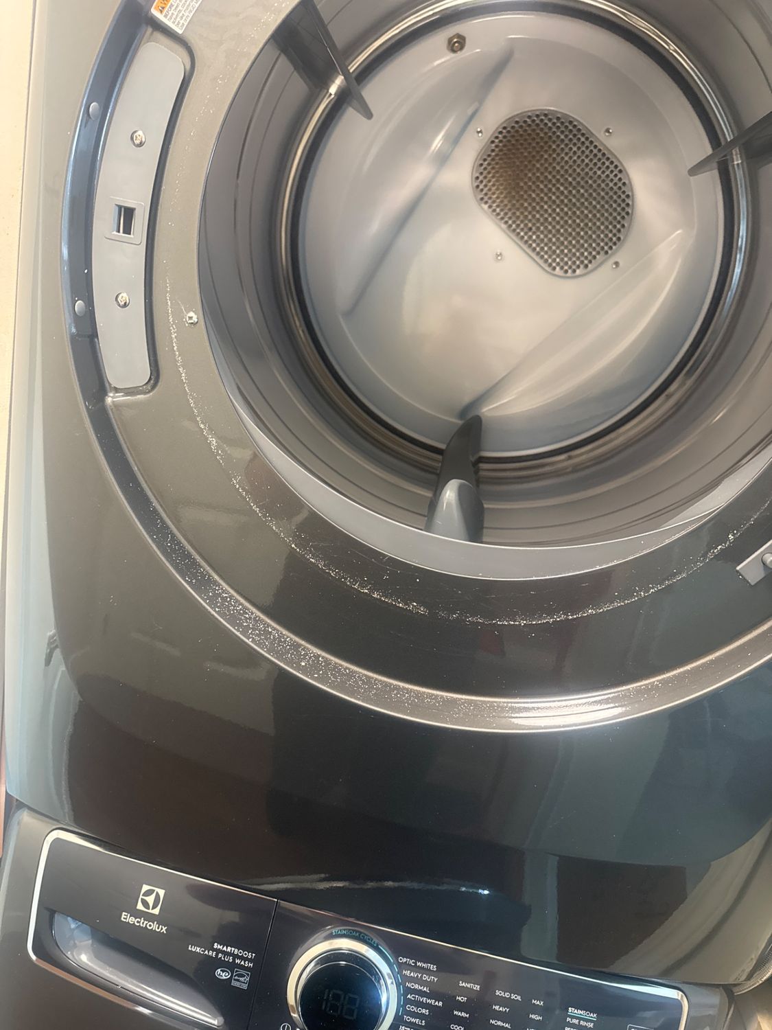 Flaky debris inside the drum of a stacked Electrolux dryer during the North Vancouver inspection