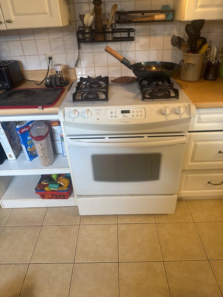 TechVill technician testing the voltage supply on a Frigidaire electric range in Edgemont North Vancouver