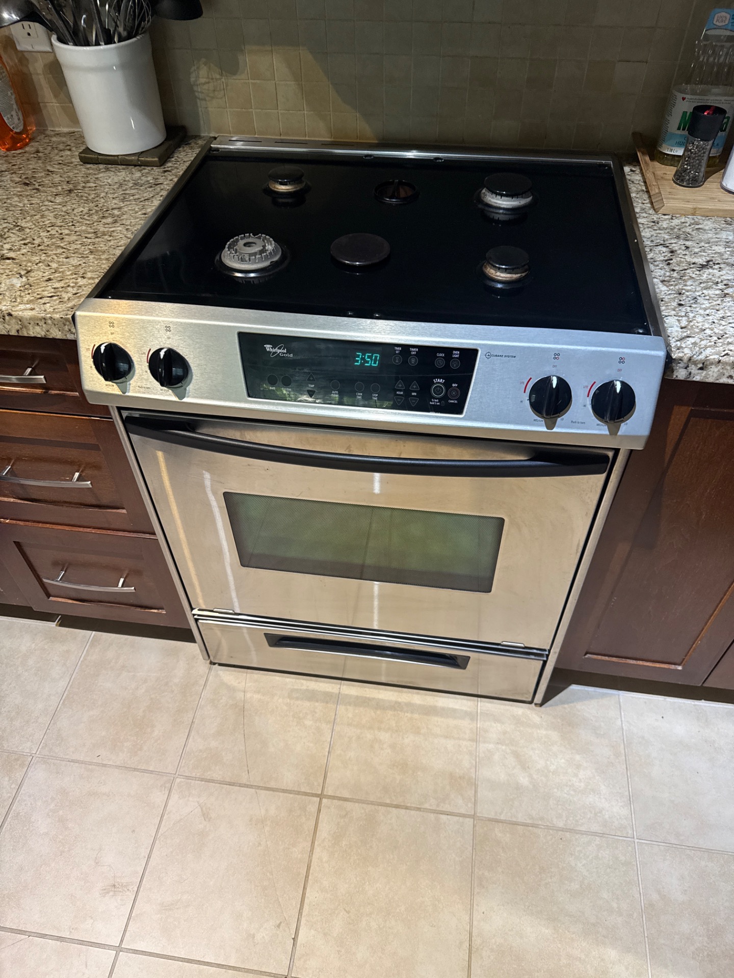 Cleaning a clogged burner on a Maytag double-oven gas range in North Vancouver
