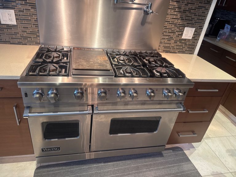 TechVill technician servicing the ignition system of a Viking 48-inch gas range in North Vancouver