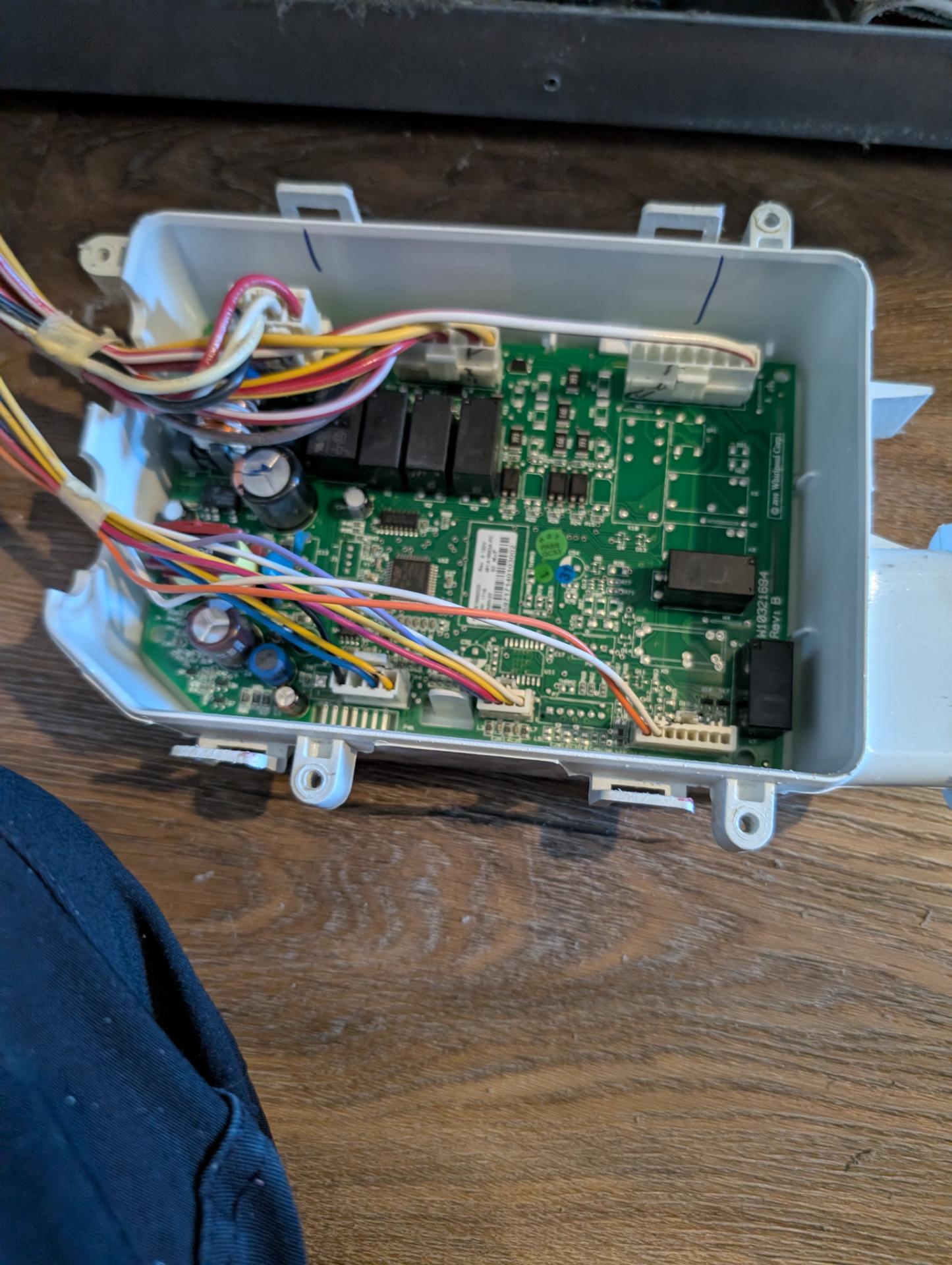 Whirlpool refrigerator main control board removed from its housing during a dual electronic repair in Stony Plain, AB