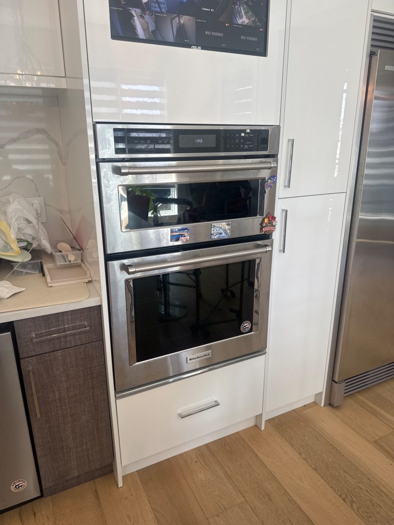 KitchenAid combination wall oven and microwave built into white cabinetry in a South Surrey, BC kitchen