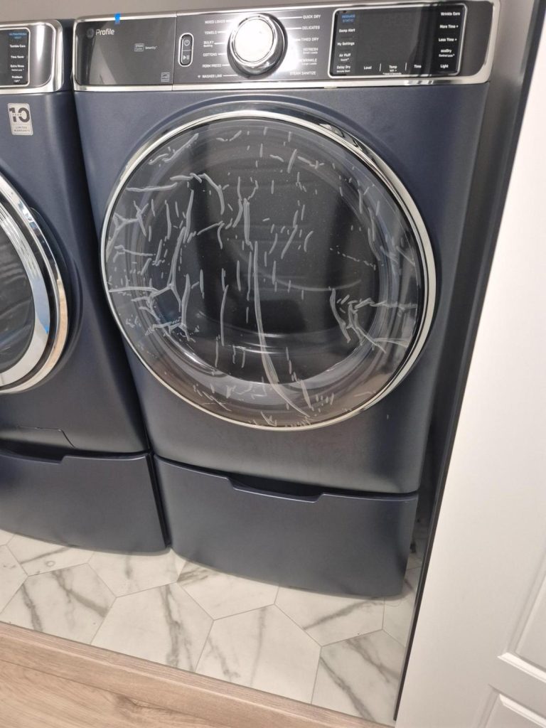GE Profile washer and dryer pair in a NW Winnipeg laundry room before the dryer diagnosis