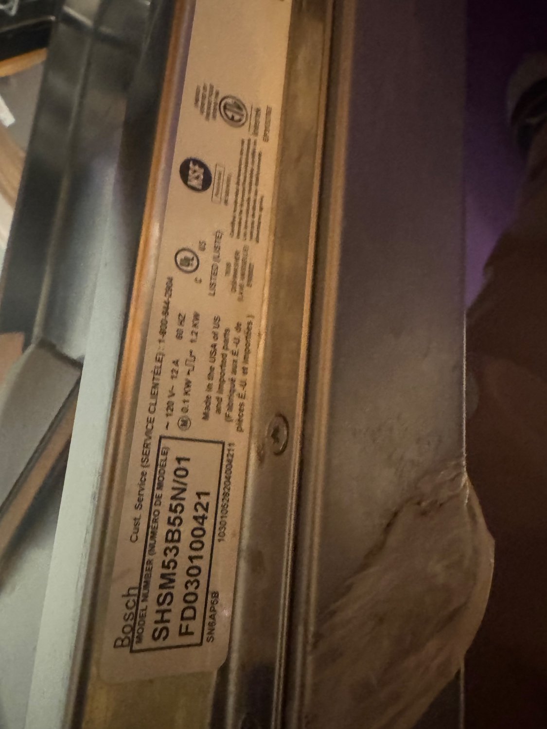 Bosch SHSM53B55N model plate on the dishwasher door edge during service in Calgary