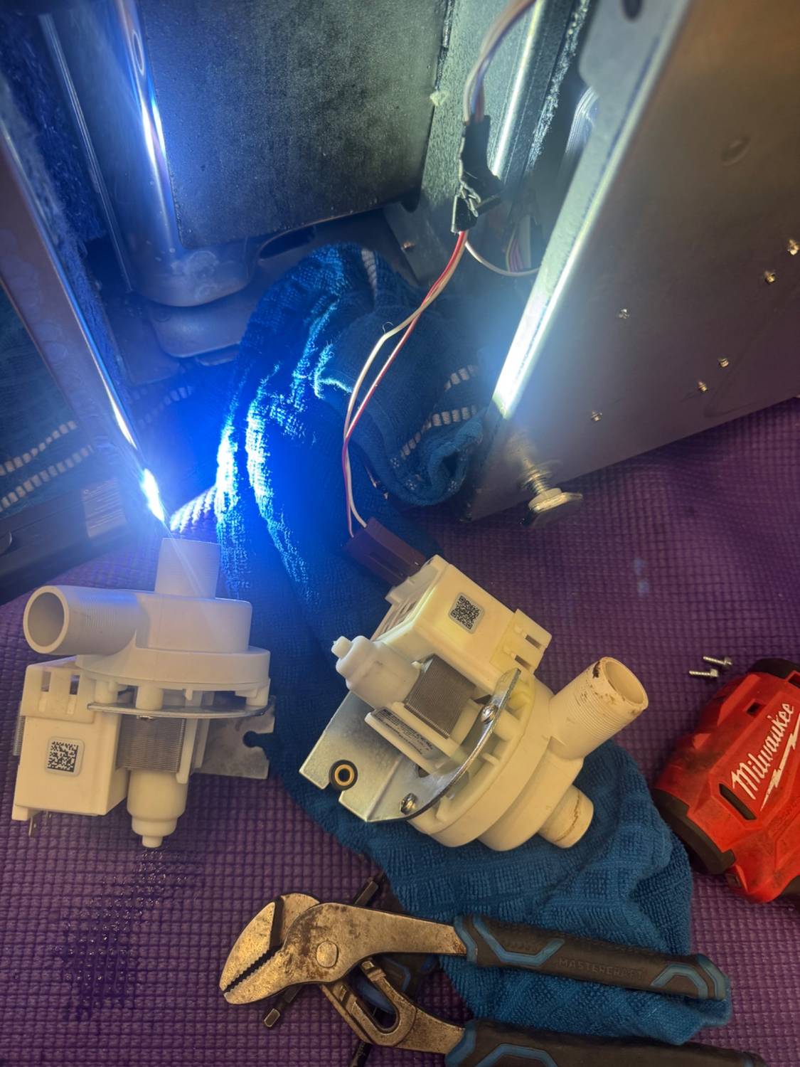 Old and new Cove drain pump motors side by side during the TechVill repair near Calgary