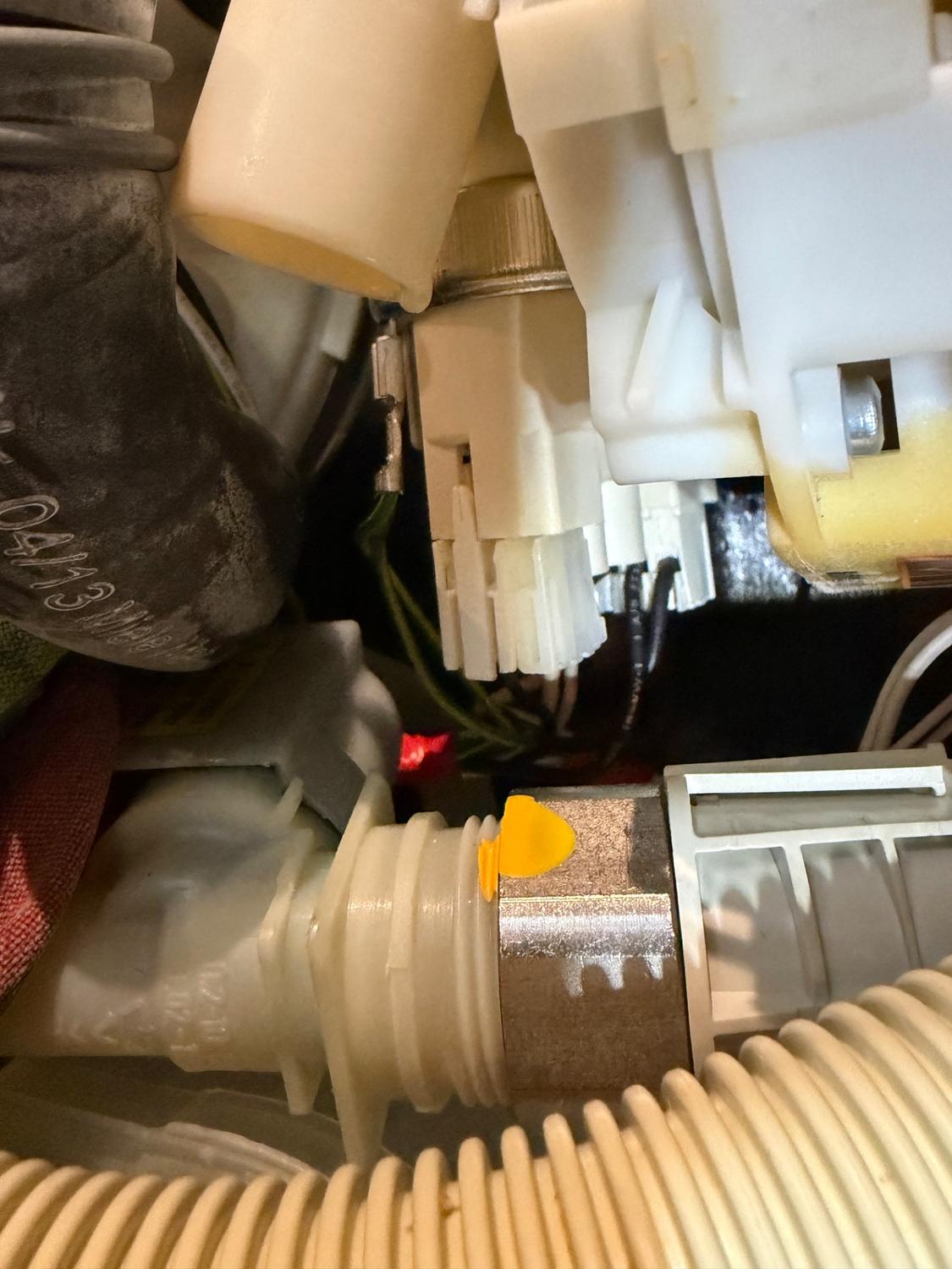 Hydraulic and wiring connections accessed during the Miele pressure switch installation in Calgary