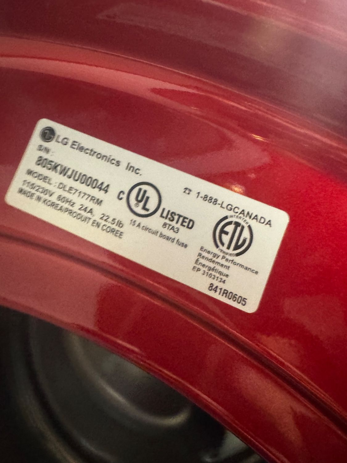 LG DLE7177RM model plate inside the dryer door opening, photographed during service in Calgary