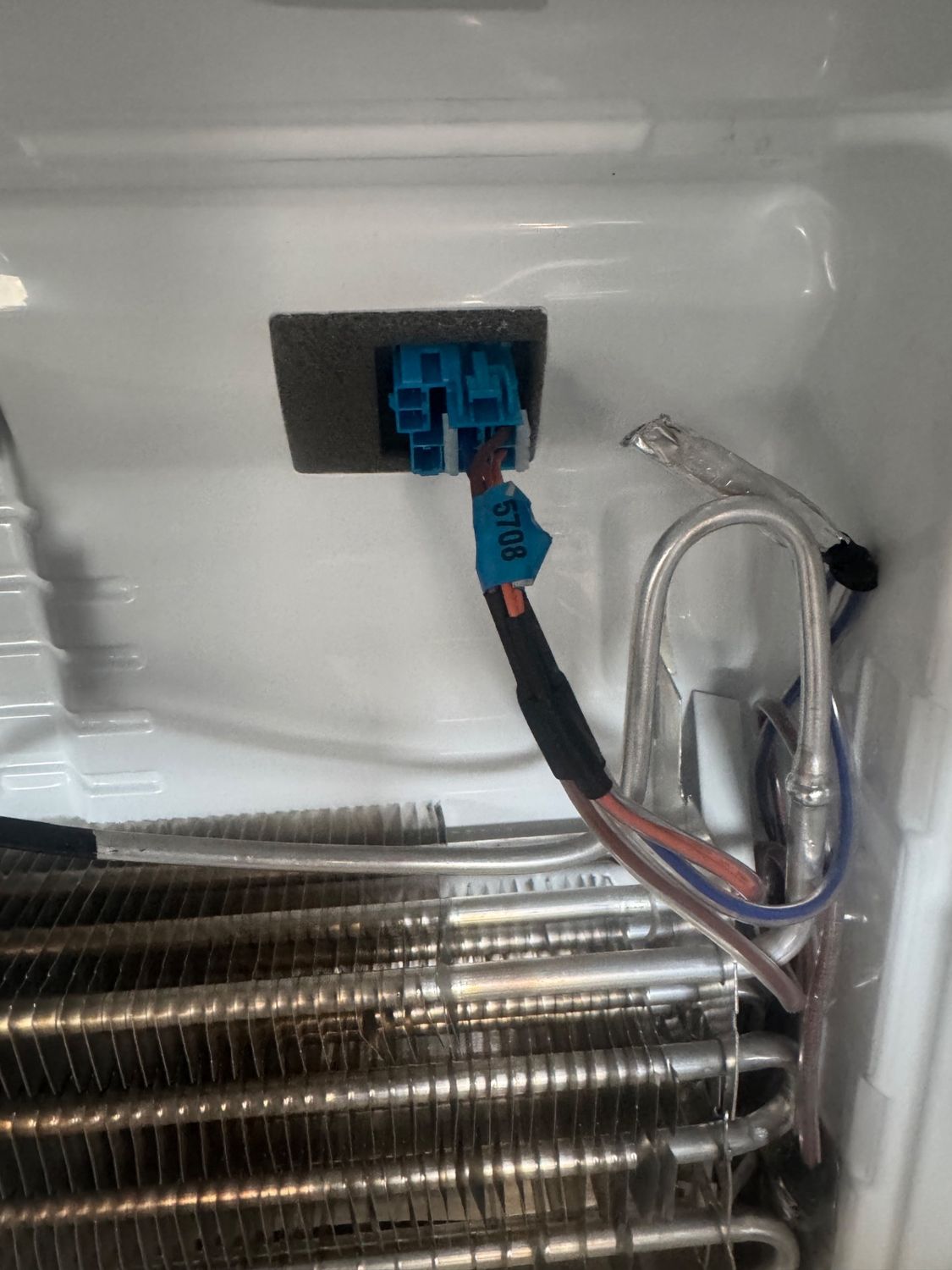 Evaporator and wiring access opened during the LG refrigerator repair showing the coil area behind the cover