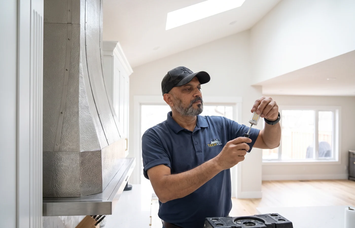 TechVill technician repairing a chimney hood fan