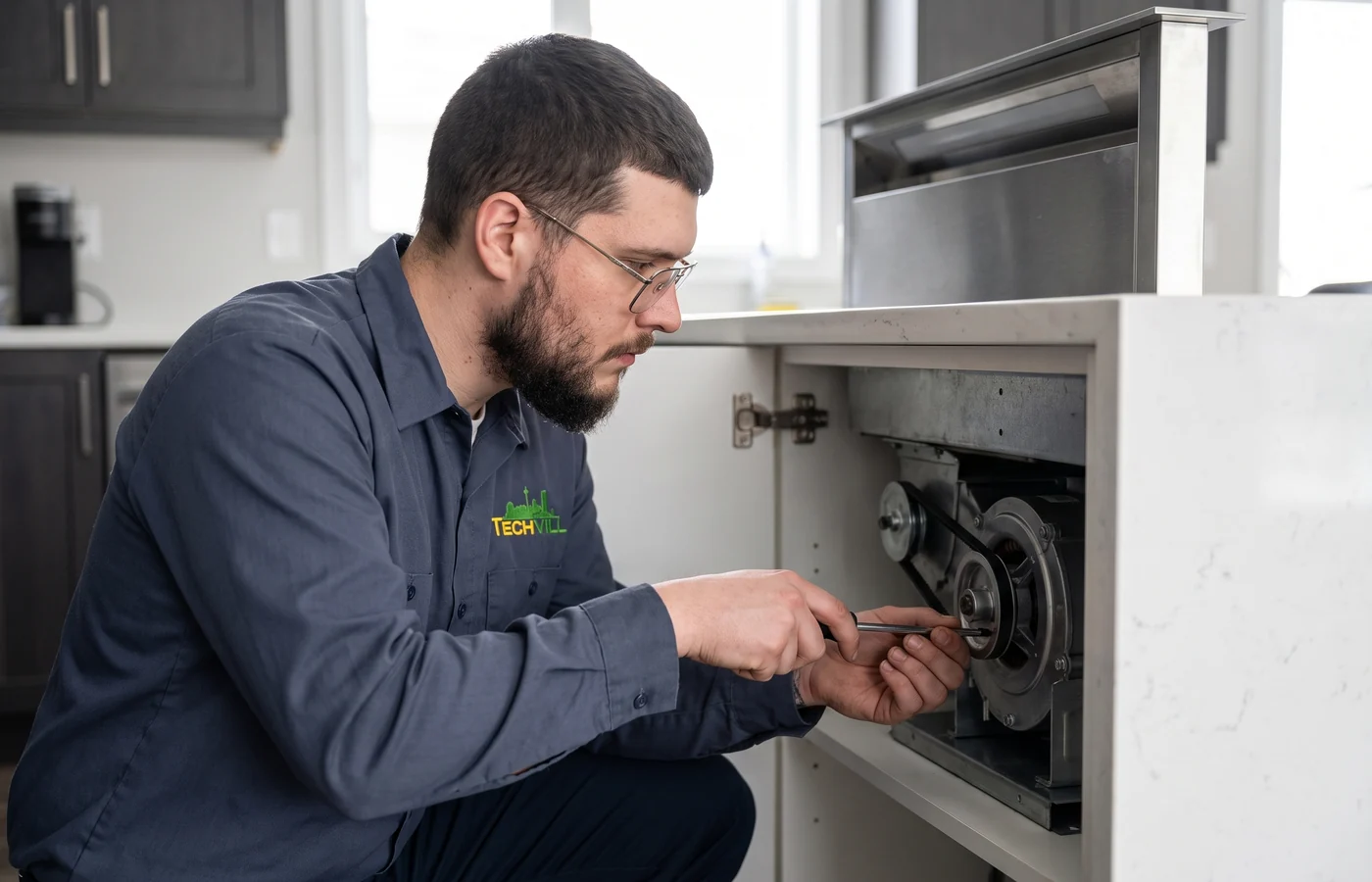 TechVill technician repairing a downdraft hood fan