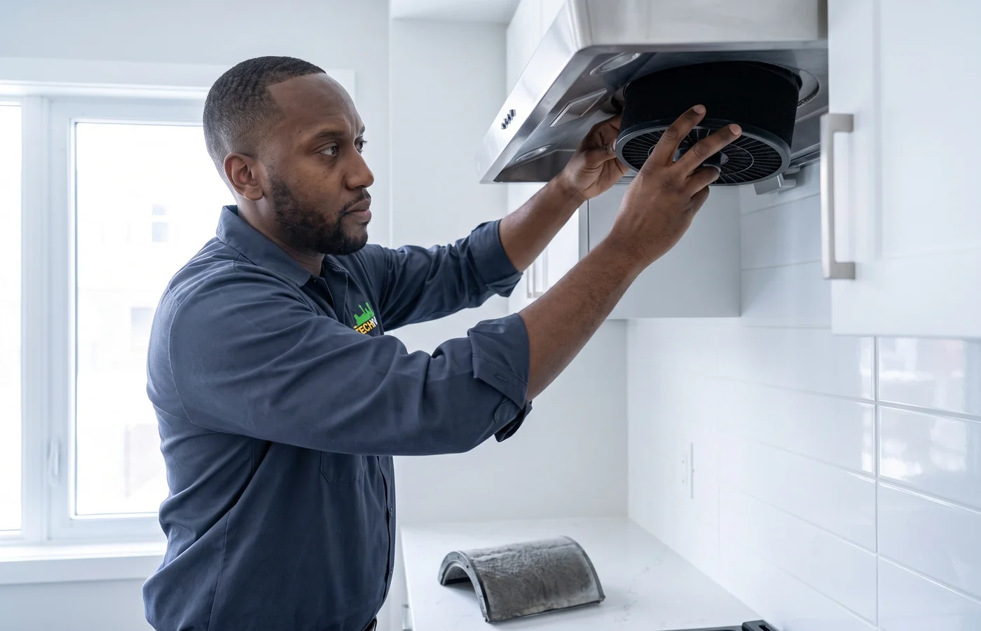 TechVill technician repairing a ductless hood fan