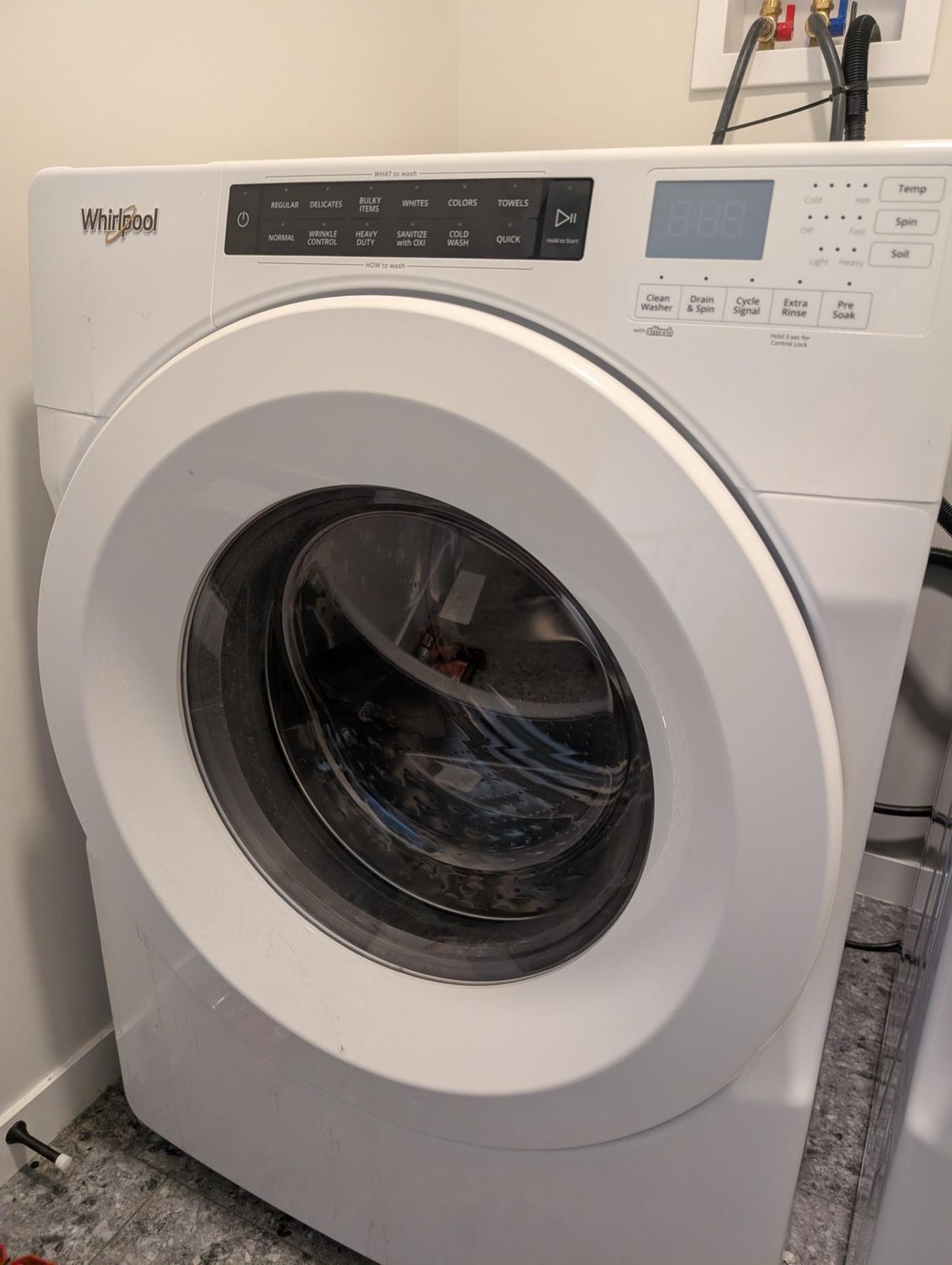 Whirlpool WFW560 front-load washer in a west Edmonton laundry closet before the diagnostic reset