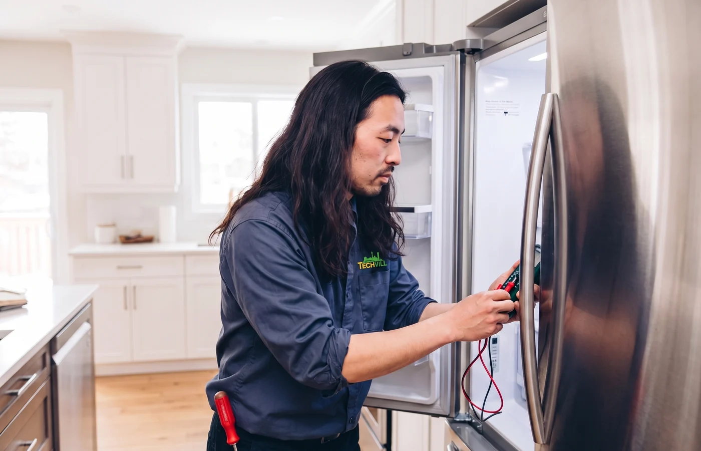 TechVill technician repairing a french door fridge