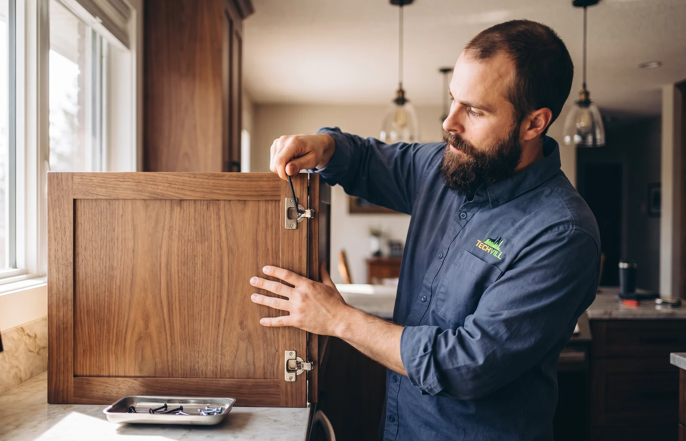TechVill technician repairing a panel-ready dishwasher