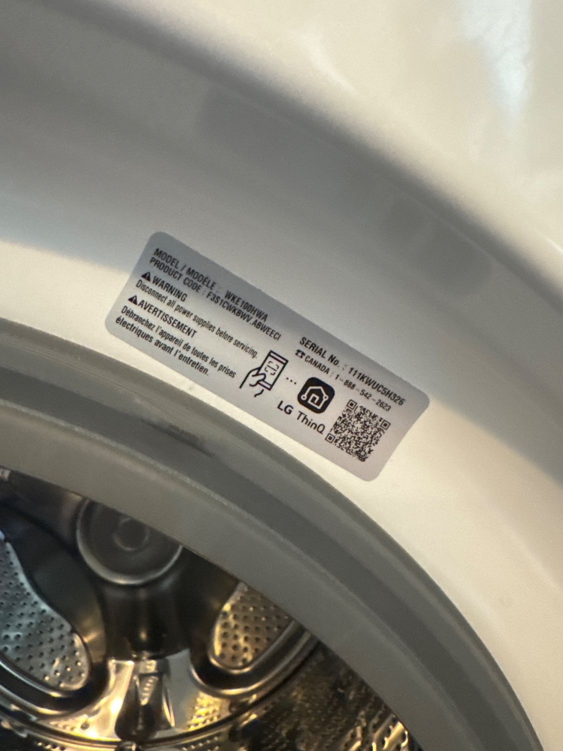 LG WKE100HWA model label on the WashTower washer door opening during TechVill diagnosis in Vancouver