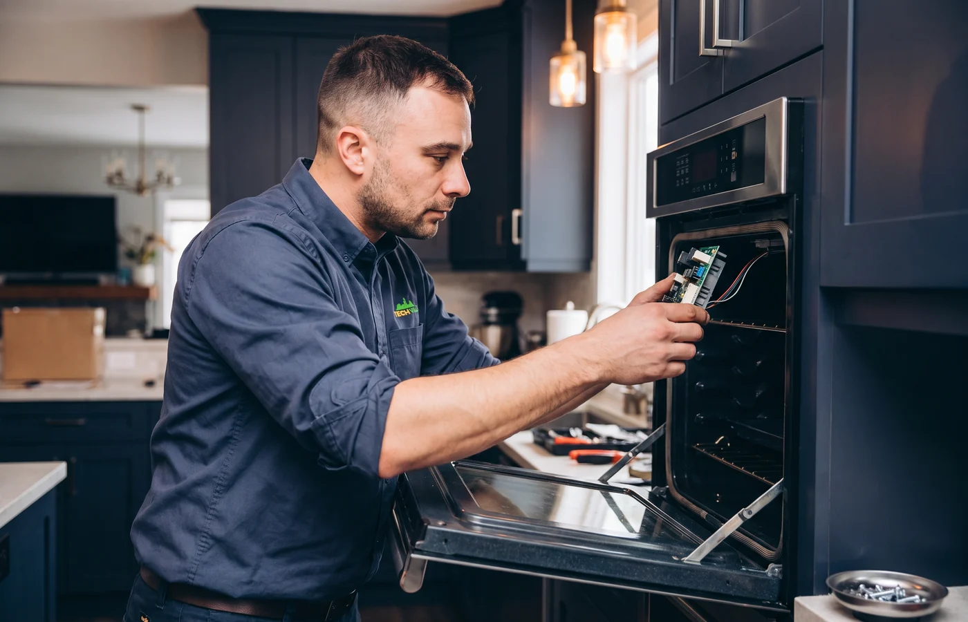 TechVill technician repairing a wall oven