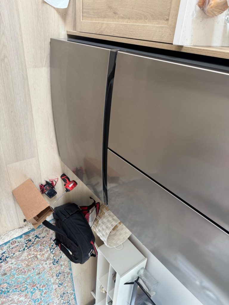 Frigidaire French door refrigerator with bottom freezer drawer during a builder warranty service call in Calgary