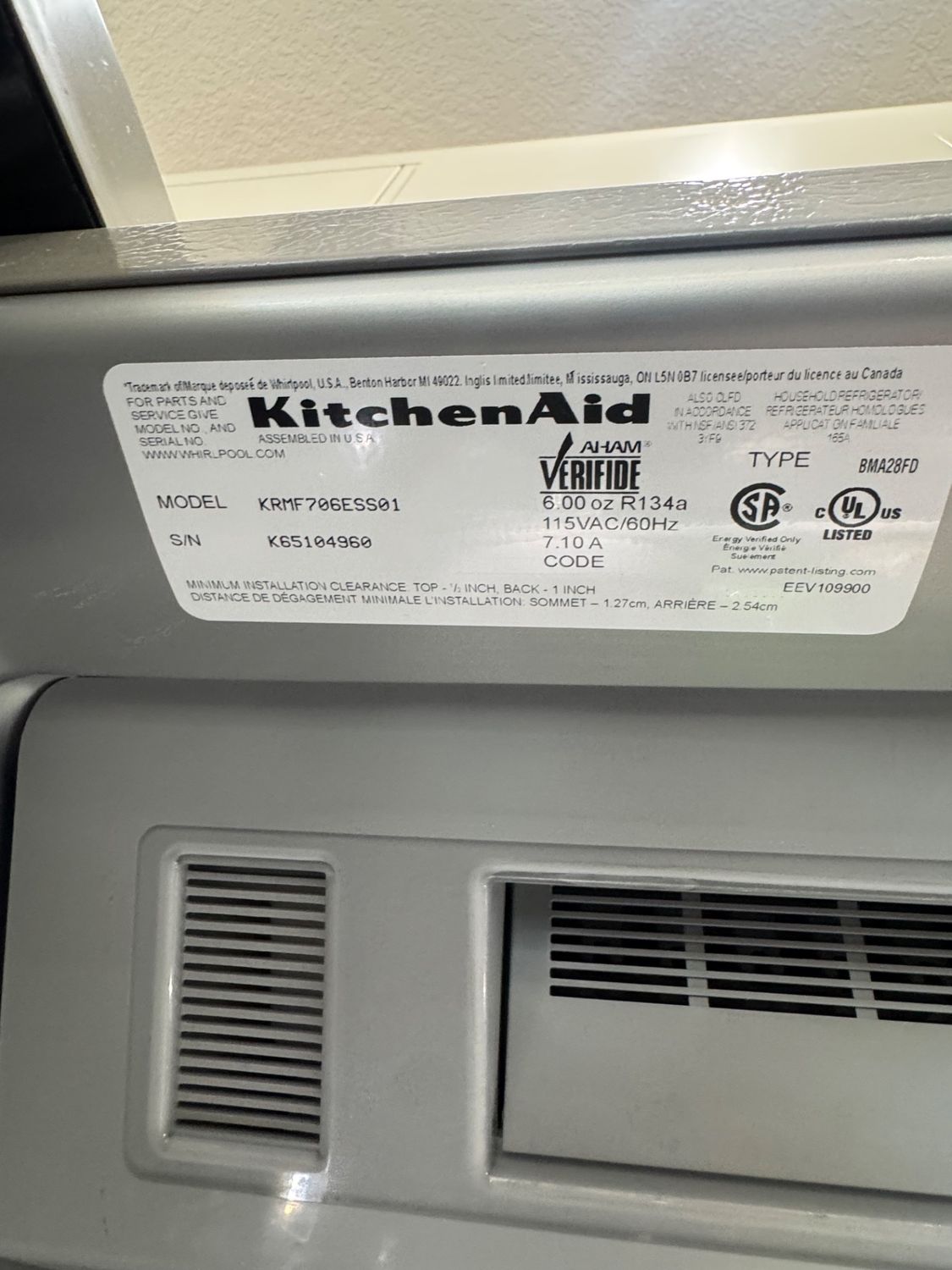 KitchenAid model KRMF706ESS01 rating plate confirming the refrigerator model and serial number during service in Calgary