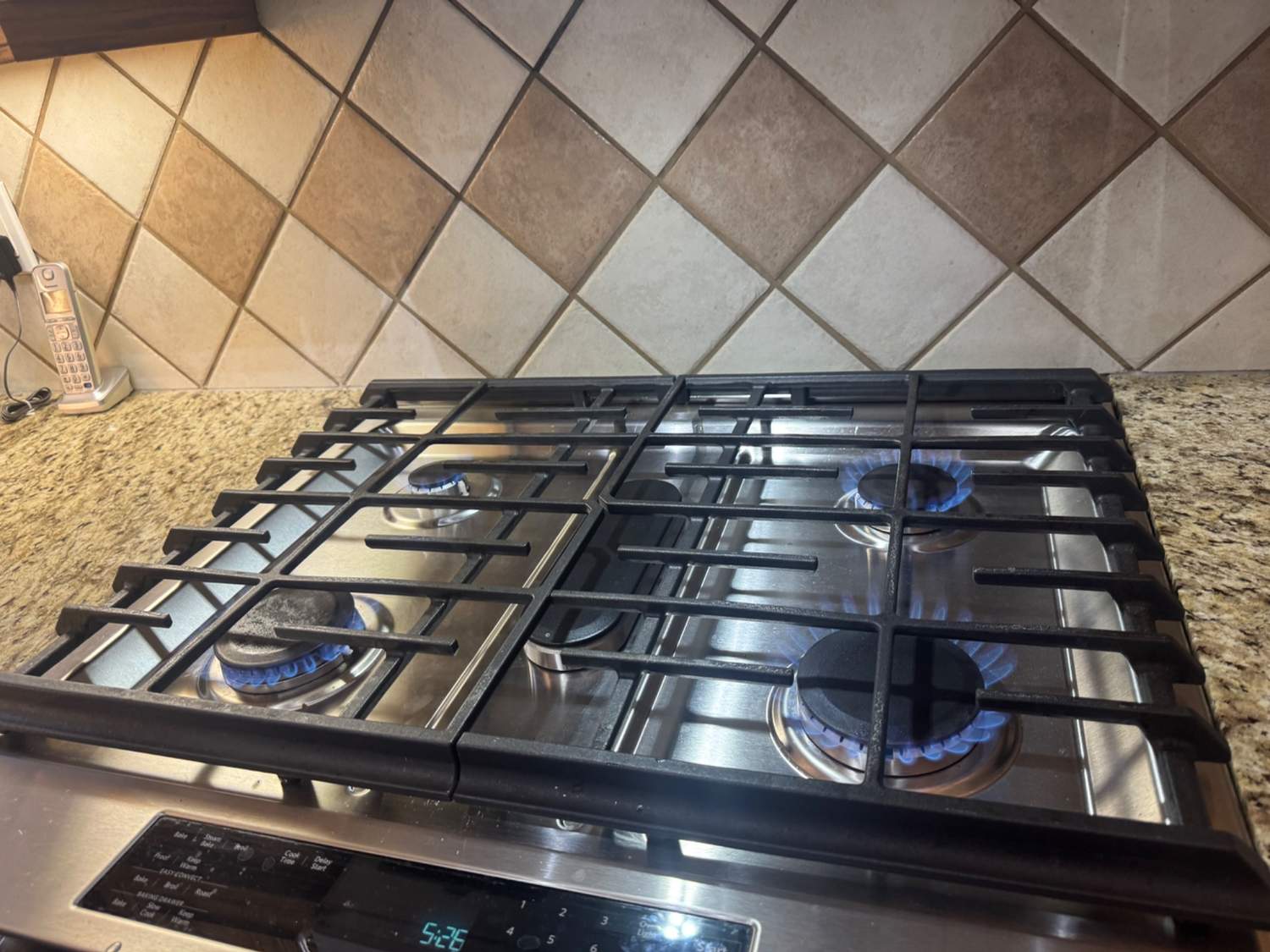 KitchenAid gas cooktop burners in Calgary burning clean blue flames after the burner caps were returned to their correct positions