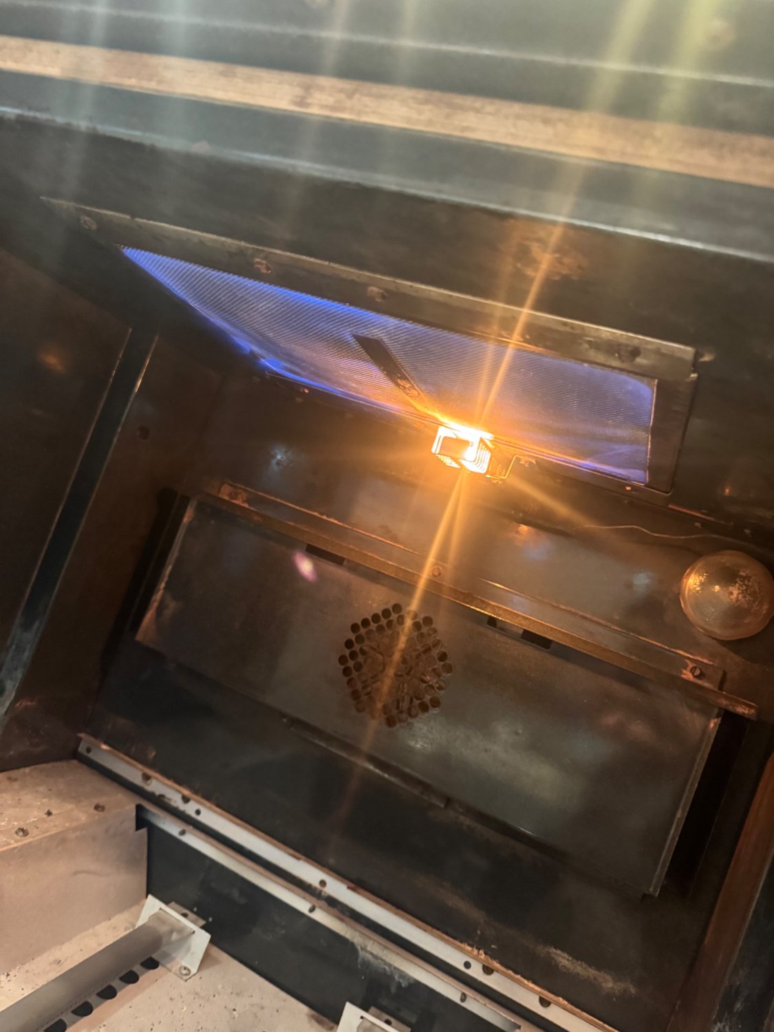 Glow igniter incandescent inside a Viking gas oven with the burner lit blue after igniter replacement in Calgary