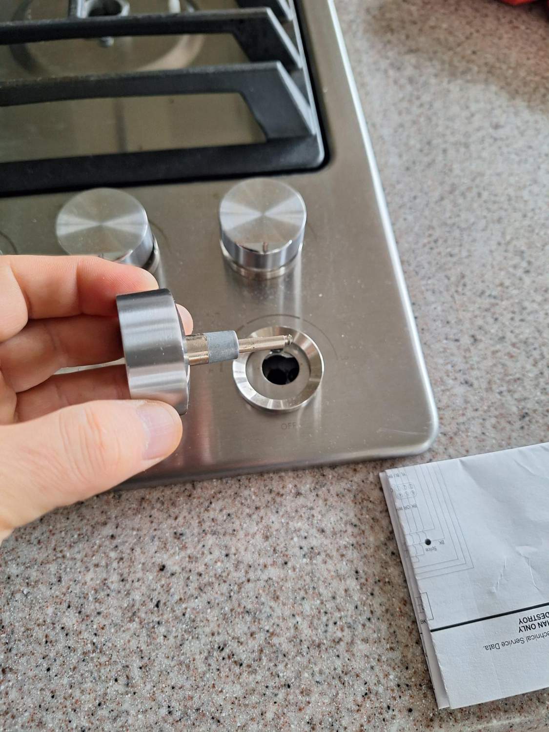 Control knob removed from a JennAir downdraft cooktop to expose the gas valve stem during diagnosis