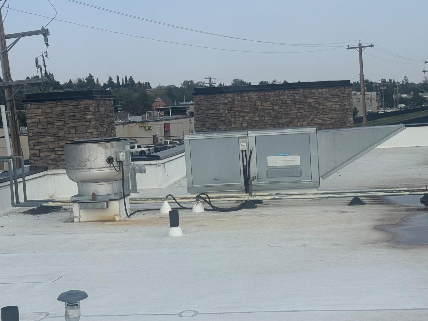 Rooftop commercial hood exhaust fan and rooftop ventilation unit at a business in Okotoks, Alberta